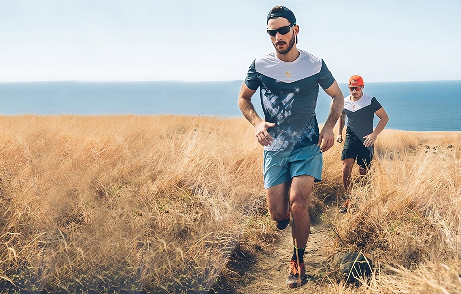 Men running together with Anchor Sunglasses Straps on a sunny day by the ocean.